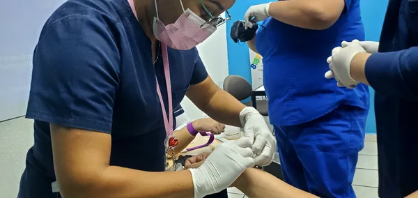 Estudiante practicando punción venosa