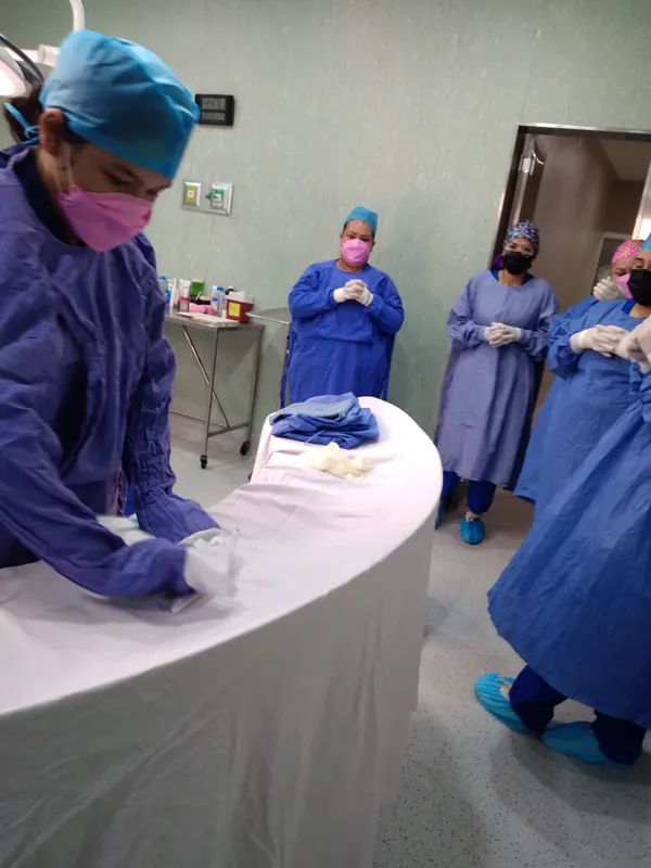 Estudiantes con bata quirúrgica en quirófano